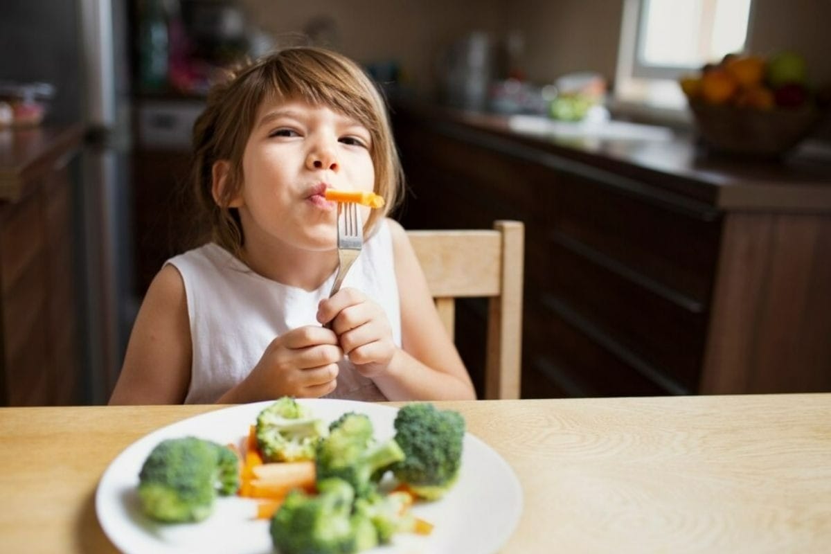Criança comendo legumes (Foto: Freepik)