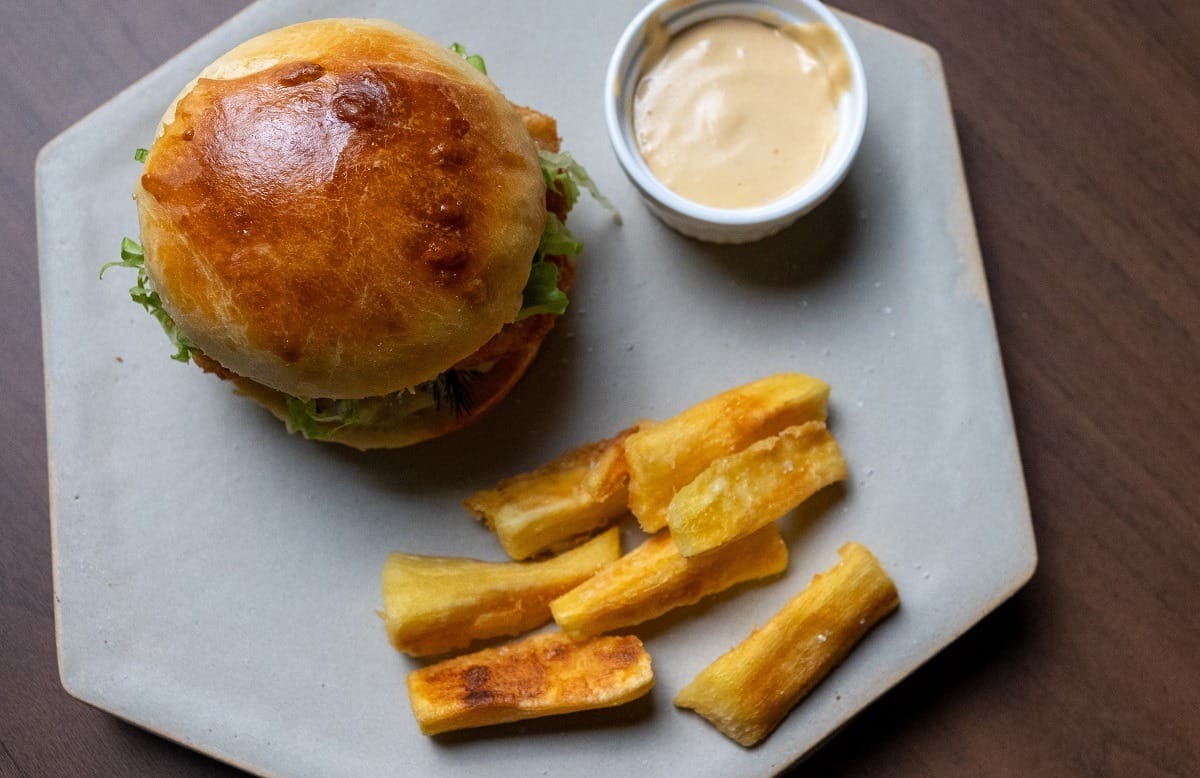 Hambúrguer de pescada amarela empanada com picles de maxixe, maionese de missô e macaxeira frita | Band Receitas