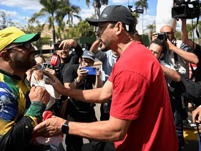 Manifestantes protestam em frente ao condomínio de Bolsonaro durante julgamento no STF