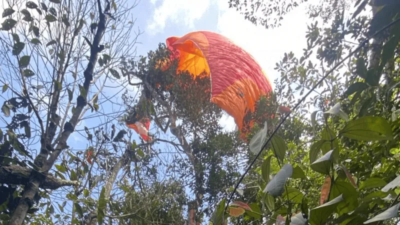Praticante de Parapente fica preso entre as árvores, em Caraguatatuba