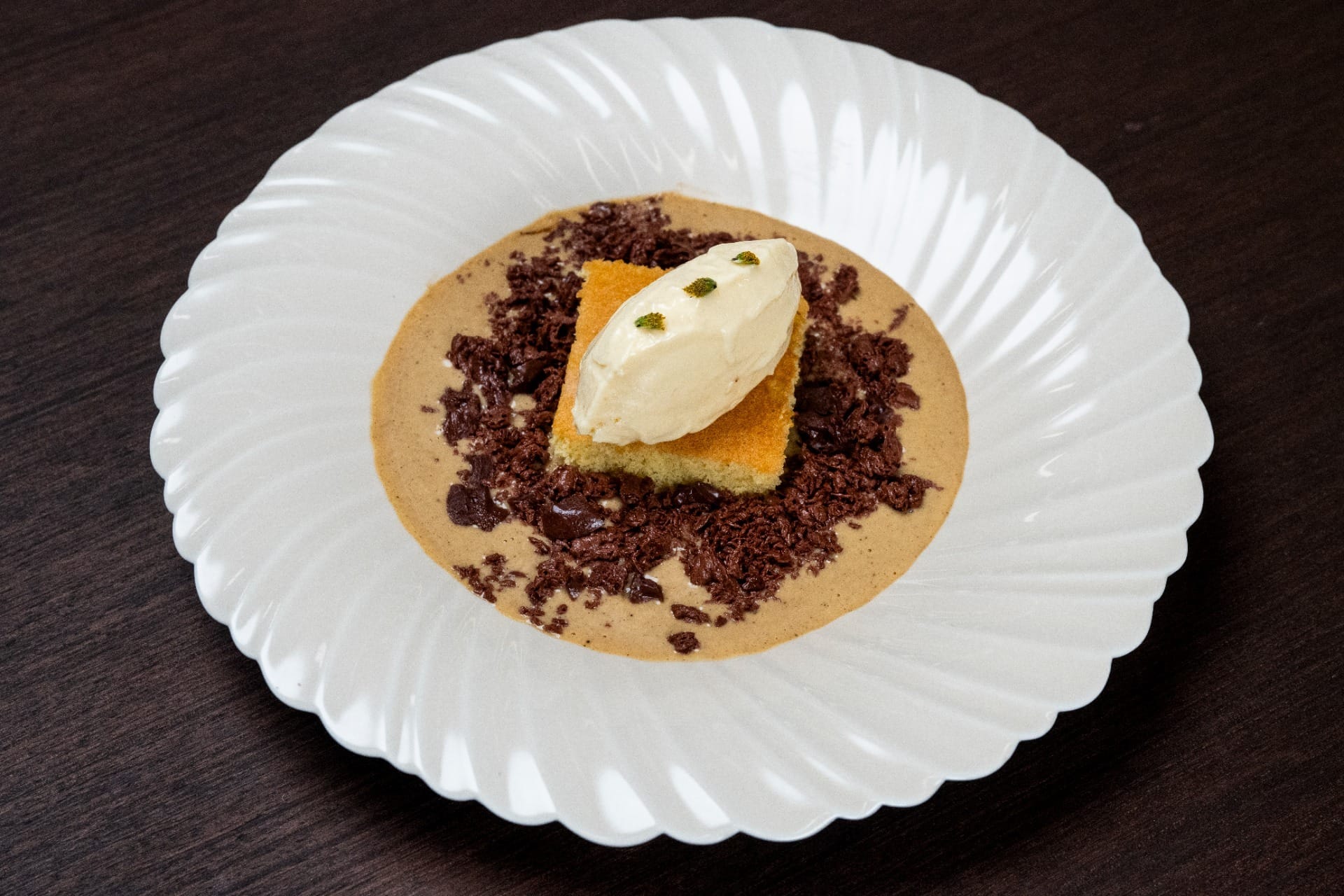 Sobremesa de cupuaçu com bolo pão de ló, ganache de chocolate, creme inglês de tucupi negro e flor de jambu | Band Receitas