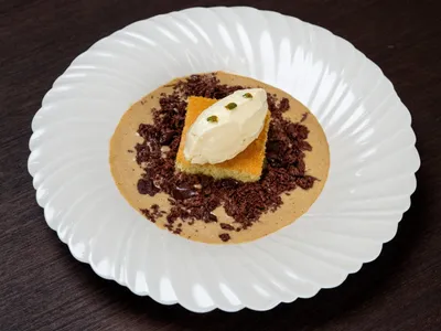 Sobremesa de cupuaçu com bolo pão de ló, ganache de chocolate, creme inglês de tucupi negro e flor de jambu | Band Receitas
