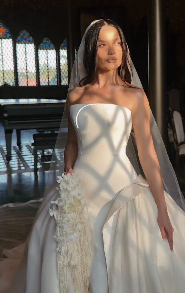 A imagem apresenta Juliette vestida de noiva, exibindo seu vestido branco tomara que caia, seus cabelos pretos soltos e um véo.