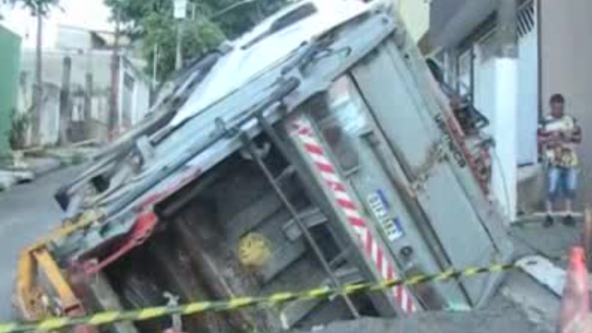 Caminhão de lixo cai em cratera após asfalto ceder em Osasco (SP)